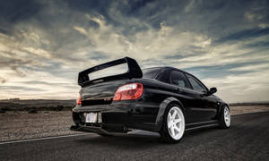 Subaru Parked On Deserted Road Wallpaper