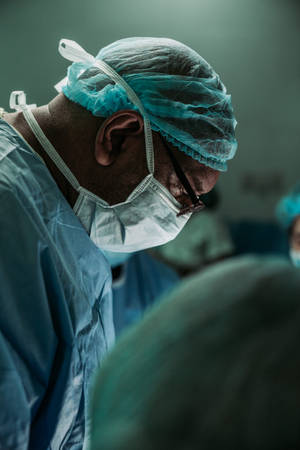 Surgeon Treating Covid19 Patient Wallpaper