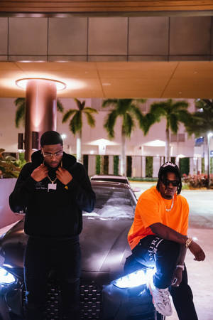 Swavy Lee Posing With His Lamborghini And Friend Wallpaper