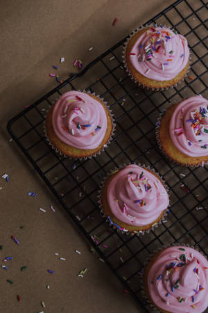 Sweet Delight: Delectable Cupcakes On A Tray Wallpaper