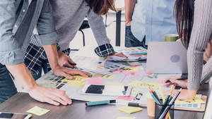 Team Brainstorming For Content On Messy Desk Wallpaper