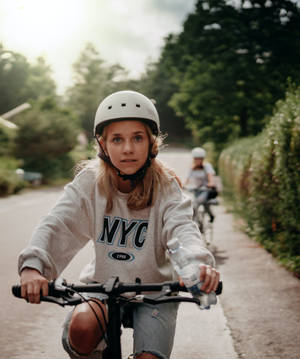 Teenage Blonde Girl Riding Bicycle Wallpaper