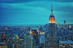 The Empire State Building Is Lit Up At Night Wallpaper