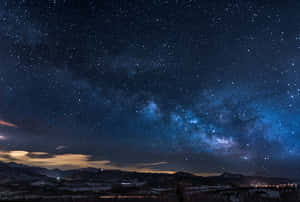 The Milky Is Seen Above A Mountain And Valley Wallpaper