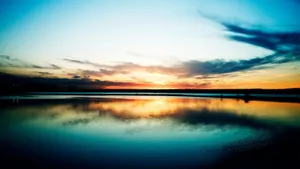 The Moon Shines Bright Over A Dark Blue Sunset Horizon Wallpaper