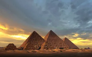 The Pyramids Of Giza Shadowed By An Overcast Sky Wallpaper