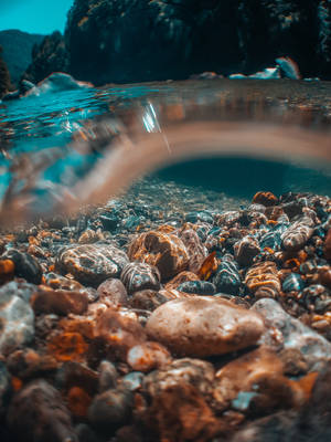 The Tranquil Turquoise Of A Submerged Stone Scene Wallpaper