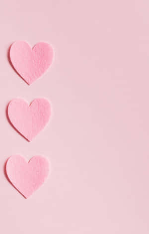 Three Pink Heart Shaped Paper On A Pink Background Wallpaper
