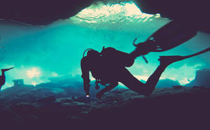 Thrilling Exploration: Scuba Diver In Underwater Cave Wallpaper