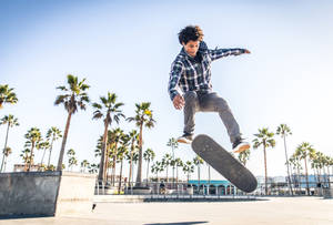 Thrilling Mid-air Capture Of A Skateboarder Executing A Nollie Fs Pop Shove-it Trick. Wallpaper