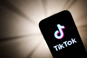 Tiktok Logo Displayed At Phone Screen Wallpaper