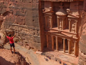 Tourist On A Cliff In Petra Wallpaper