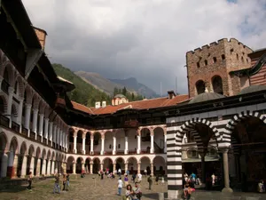 Tourists Exploring The Majestic Rila Monastery In Bulgaria Wallpaper