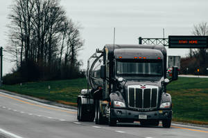 Trailer Truck Near Highway Sign Wallpaper