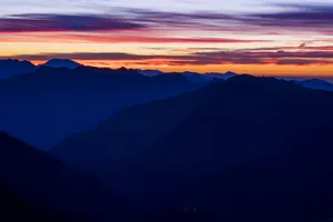 Travel To New Heights With A Beautiful Mountain Sunset. Wallpaper