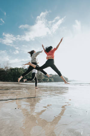 Trio Jumping On Shore Wallpaper