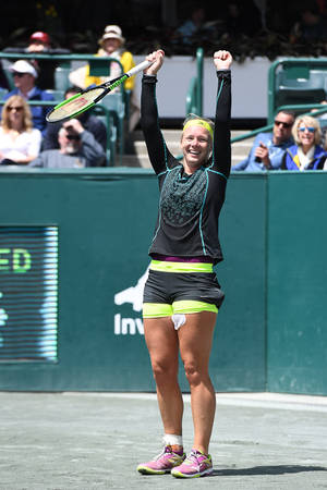 Triumphant Kiki Bertens With Arms Raised Celebrating Victory Wallpaper