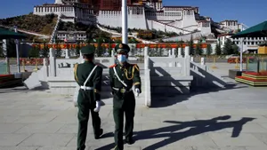 Two Men In Front Of Potala Palace In Lhasa Wallpaper