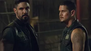 Two Men In Vests Standing Next To Each Other Wallpaper