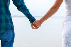 Two People Embracing In Front Of A Scenic Landscape Wallpaper