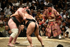 Two Sumo Wrestlers Clashing In An Epic Showdown Wallpaper