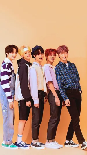 Txt Smiling Against An Orange Background Wallpaper