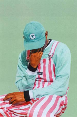 Tyler The Creator Rocking His Signature Look: Bold Stripes, Pants, And Cropped Jacket. Wallpaper