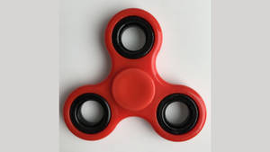 Unwind Your Thoughts With Red Fidget Toy Wallpaper