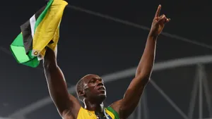 Usain Bolt Triumphantly Cheering With Jamaican Flag Wallpaper