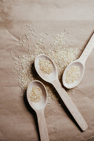 Variety Of Raw Rice On Three Spoons Wallpaper