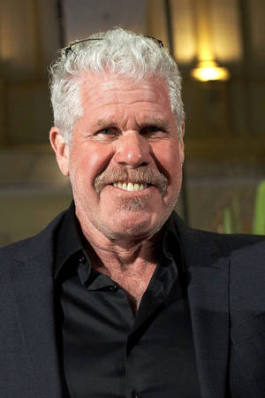 Veteran Hollywood Actor Ron Perlman In Sophisticated Black Attire Wallpaper