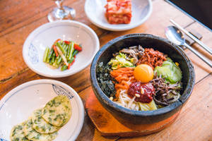 Vibrant And Delicious Bibimbap With Pajeon Meal. Wallpaper