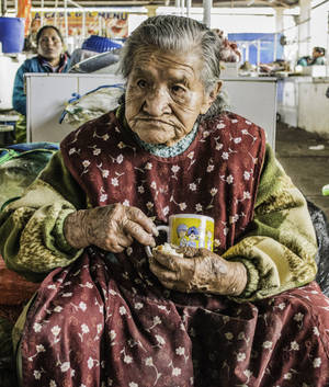 Vibrant Elderly Woman Shopping In A Local Market Wallpaper