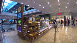 Vibrant Fruit Stand In A Bustling Mall Wallpaper