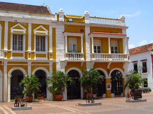 Vibrant Yellow Building In Lively Cartagena Wallpaper