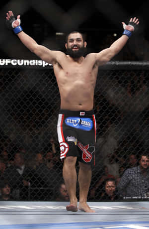 Victorious Moment – Johny Hendricks Celebrating His Win In The Octagon Wallpaper
