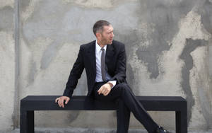 Vincent Cassel Sitting On Bench Wallpaper