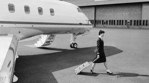 Vintage Flight Attendant In Front Of Airplane Wallpaper