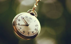 Vintage Timekeeper: Hanging Retro Pocket Watch Wallpaper