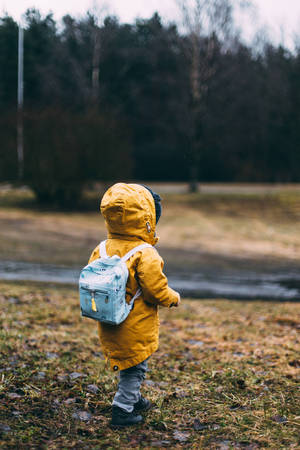 Walking Child In Yellow Raincoat Wallpaper