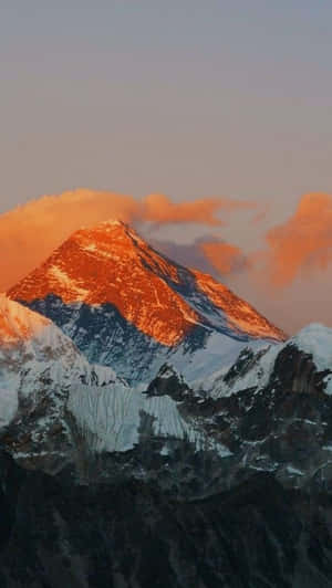 Watch The Sun Dip Below The Snow-capped Mountain Tops At Sunset. Wallpaper