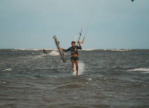 Windsurfing And Walking In Ocean Wallpaper