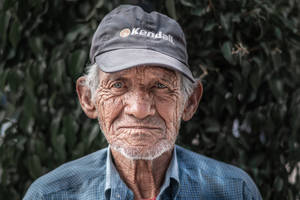 Wise Gaze - An Elderly Man In A Baseball Cap Wallpaper