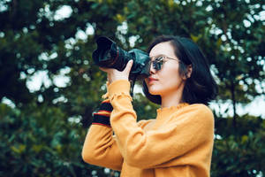 Woman Capturing Beauty Of Nature Through Lens Wallpaper