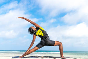 Woman Doing Pilates On Beach Wallpaper