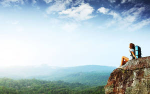 Woman Sitting On A Cliff Overlooking A Mountain Wallpaper