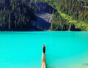 Woman Standing Over Beautiful Blue Water Wallpaper