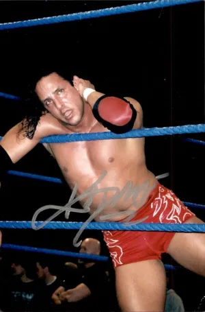 Wrestler_in_ Red_ Trunks_ Resting_on_ Ropes_ Signed_ Photo Wallpaper