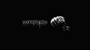 Xxxtentacion Using A Laptop In A Creatively Set Environment Wallpaper