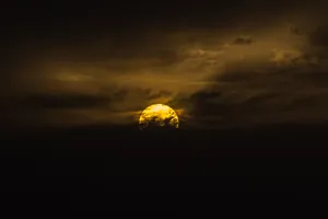 Yellow Sun Over Dark Clouds Wallpaper